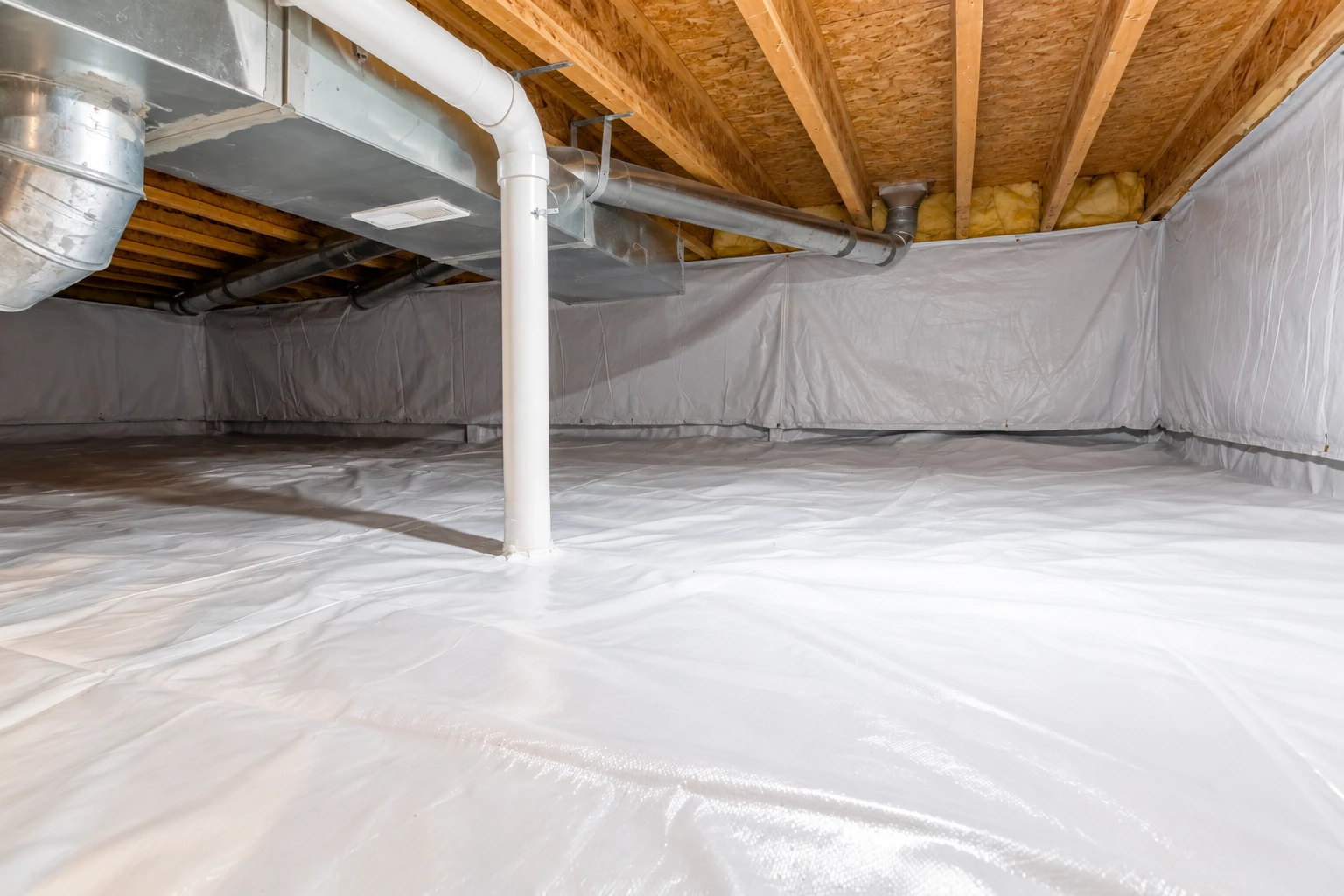 A crawl space has white vapor-barrier sheeting across the floor and walls, with exposed ducts and floor joists above.